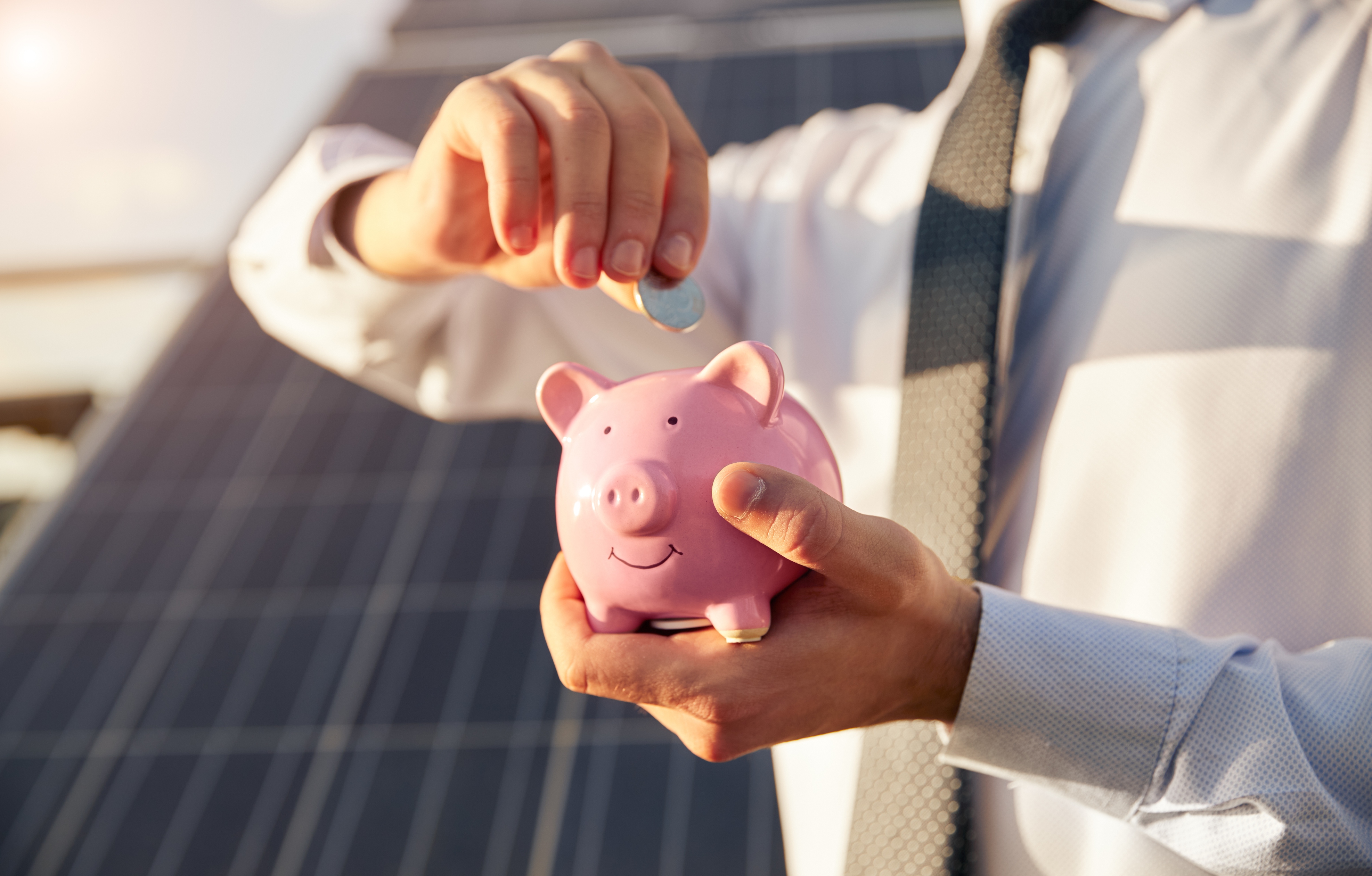Piggy bank with solar panels in the background